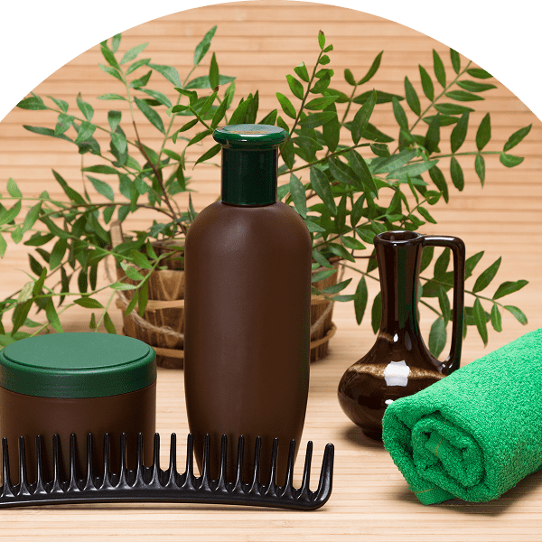 Hair products with plants and green towel.